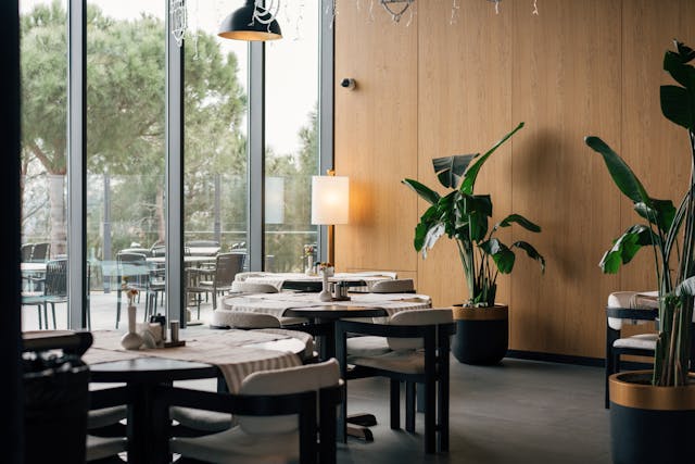 Empty, bright modern office with large windows, polished floor, and exposed ceiling.